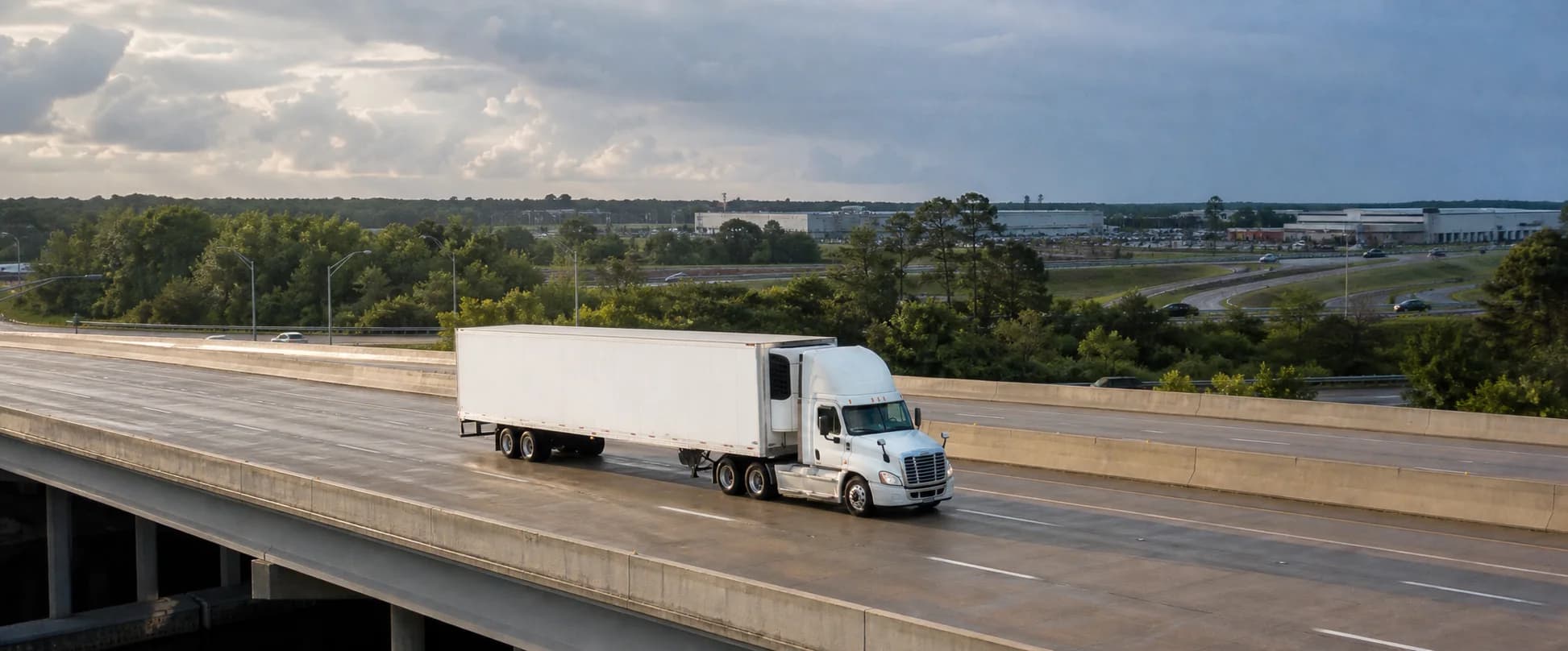 Refrigerated tractor-trailer crossing an East Coast interstate overpass